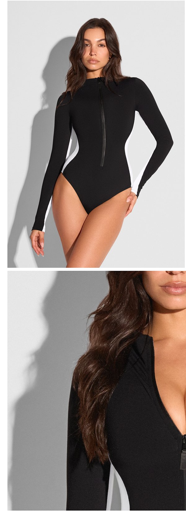 Black long-sleeve swimsuit with a front zipper and white side panels.