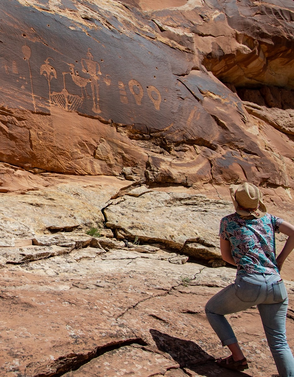 a woman standing in front of a large rock