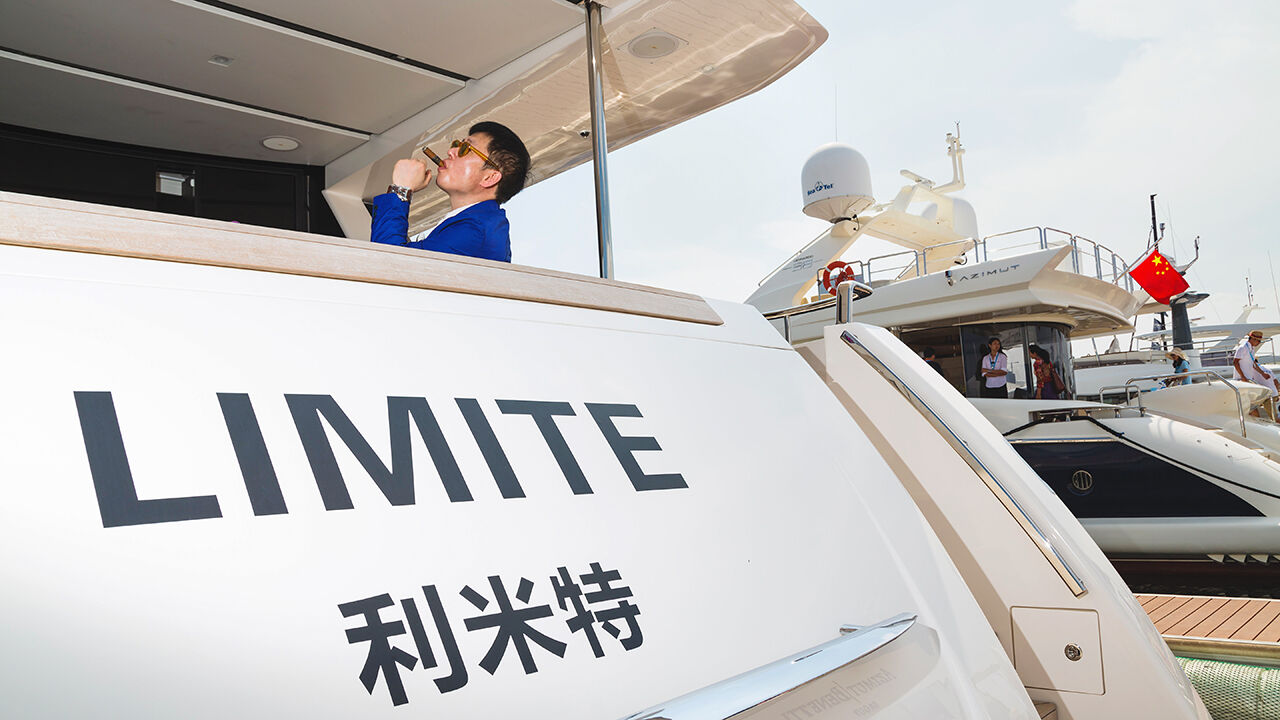 A man smokes a cigar on a yacht at the SO! Dalian yachting event in China in 2014