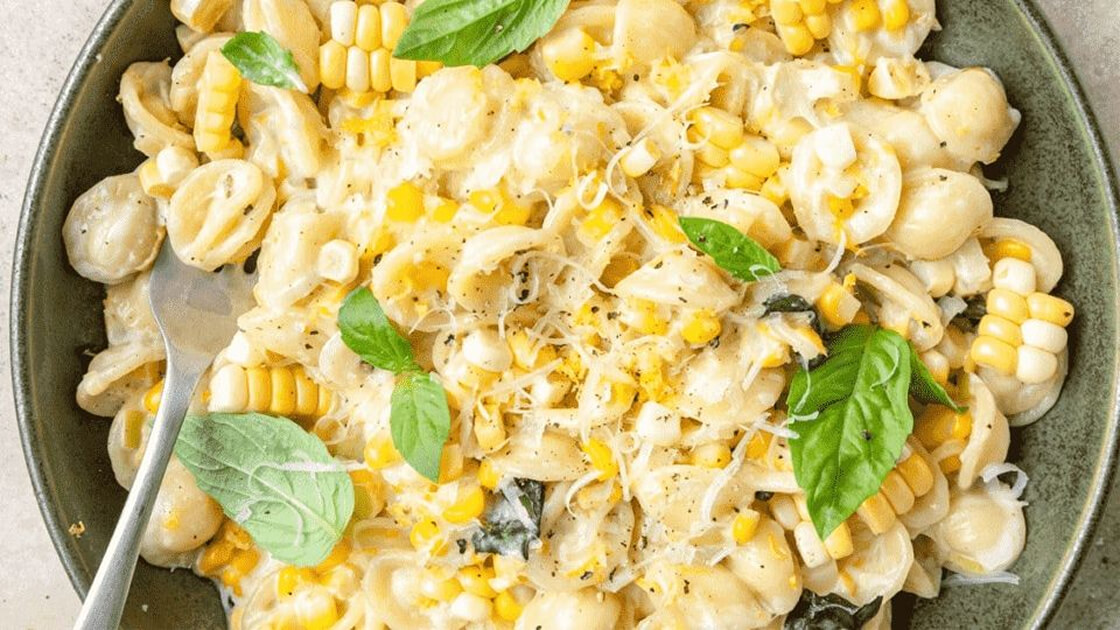 Creamy corn basil pasta on a plate.