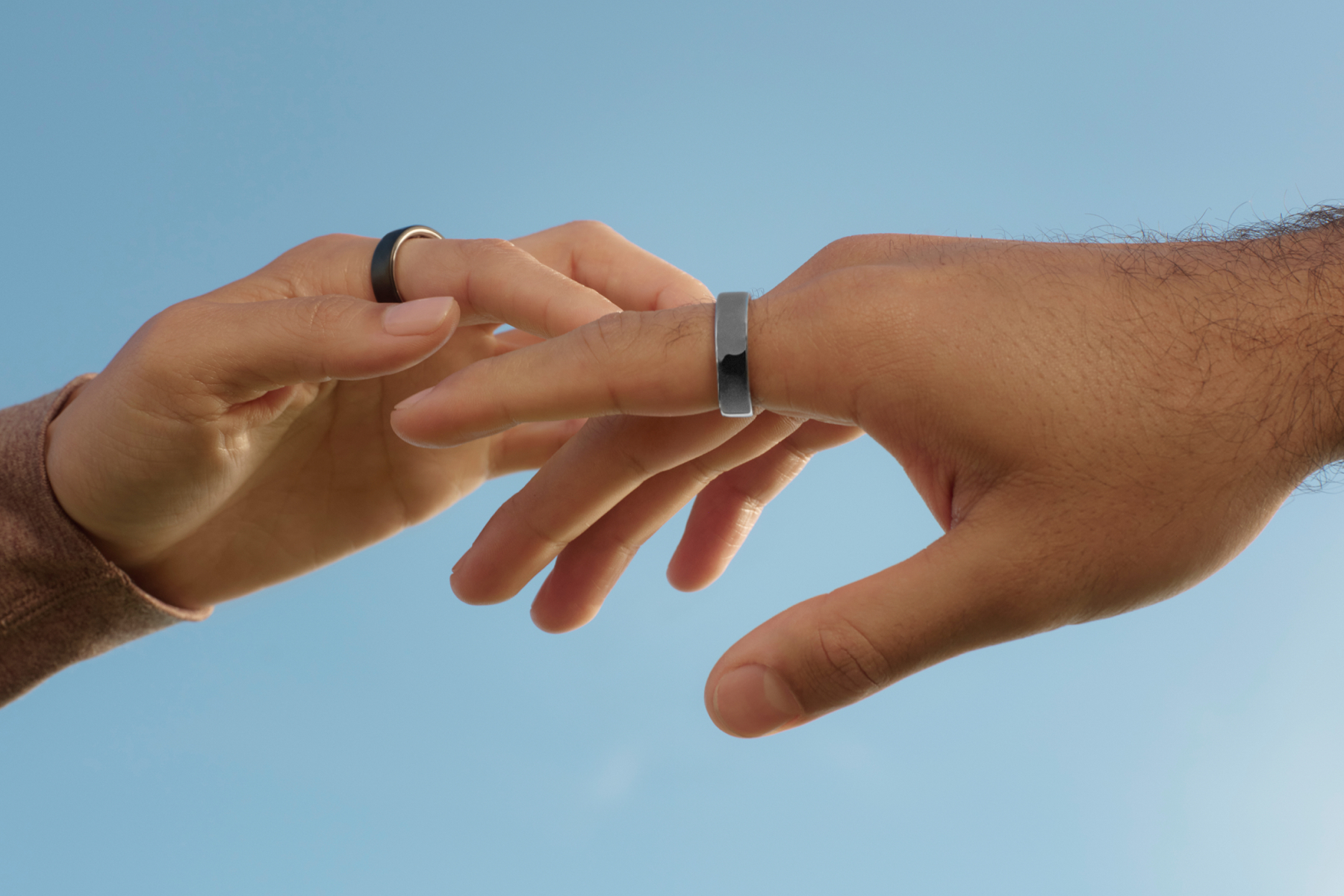 Hands wearing the Oura Ring 5 on index fingers