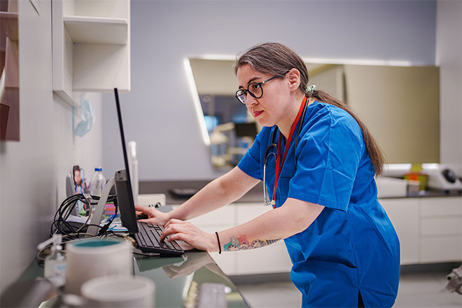 A nurse works at a computer.