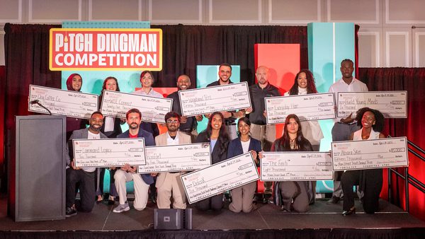 winners hold up giant checks on stage at Pitch Dingman Competition