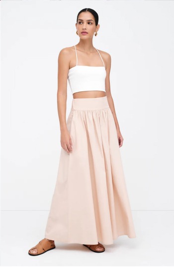 Astrid in a white crop top and the Raven Skirt stands with one hand relaxed by her side.
