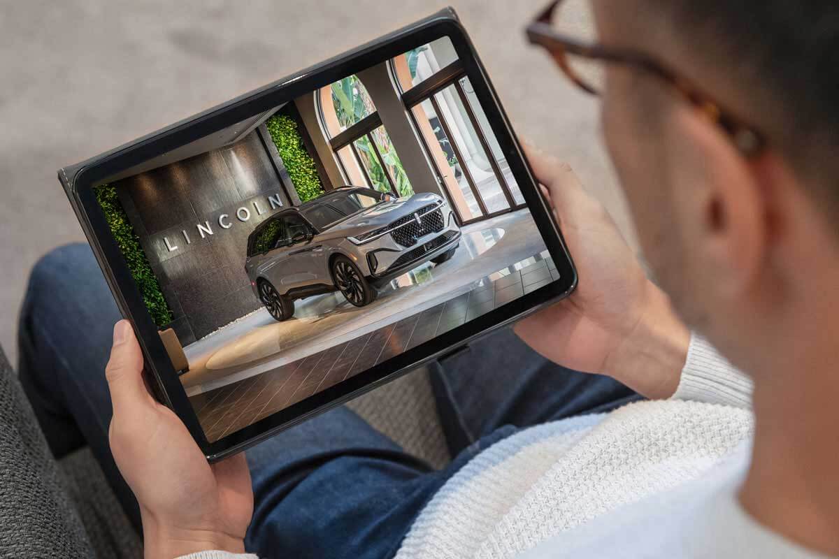 A man looks at a Lincoln vehicle on tablet device.