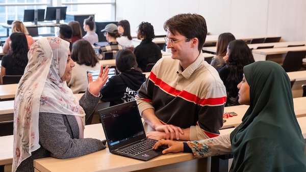 Students and instructor working together in a classroom at Carleton