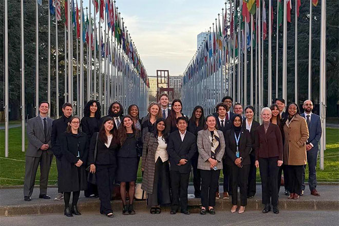 Students in front of flags at the United Nations building in Geneva.