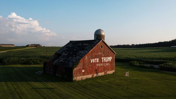 Aerial view of a barn on a farm that says 'Vote Trump' written on it.