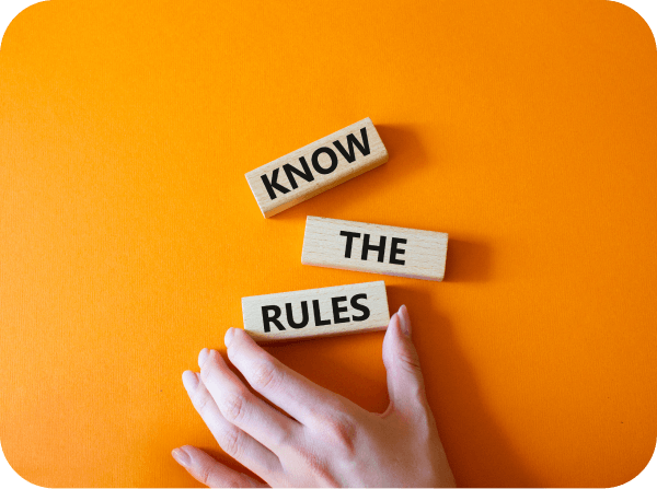 An orange background with a hand near blocks that reads: Know The Rules