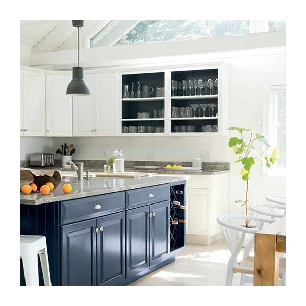 A white-painted kitchen with white cabinets, and dark blue-gray island cabinets.