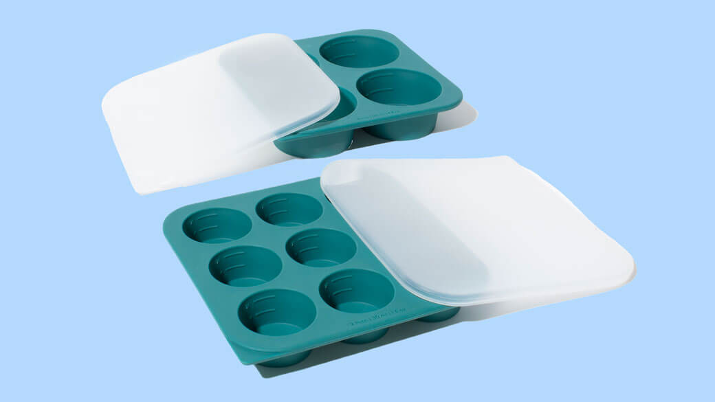 Anyday Anytime Freezer Trays with lids, made from flexible food-grade silicone, shown in two sizes with a teal color and white covers. These trays are designed for freezing soups, sauces, and meal prep portions, making microwave cooking and storage easier.