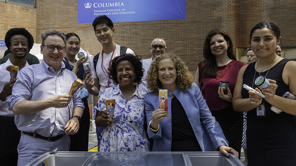 Columbia President Jennifer Mnookin and several other people smile and pose while holding ice cream cones and popsicles at Columbia University Irving Medical Center’s Haven Plaza on a warm summer day. 