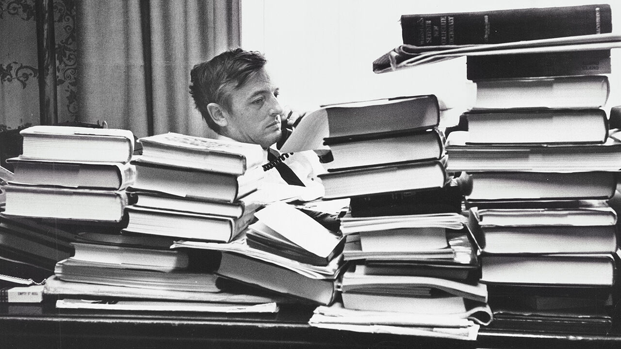 William Buckley in his office surrounded by piles of books