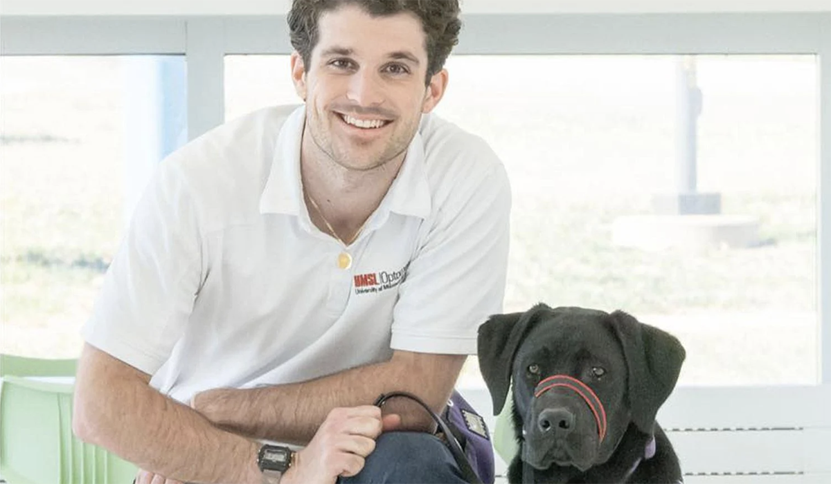 A man poses with a dog.