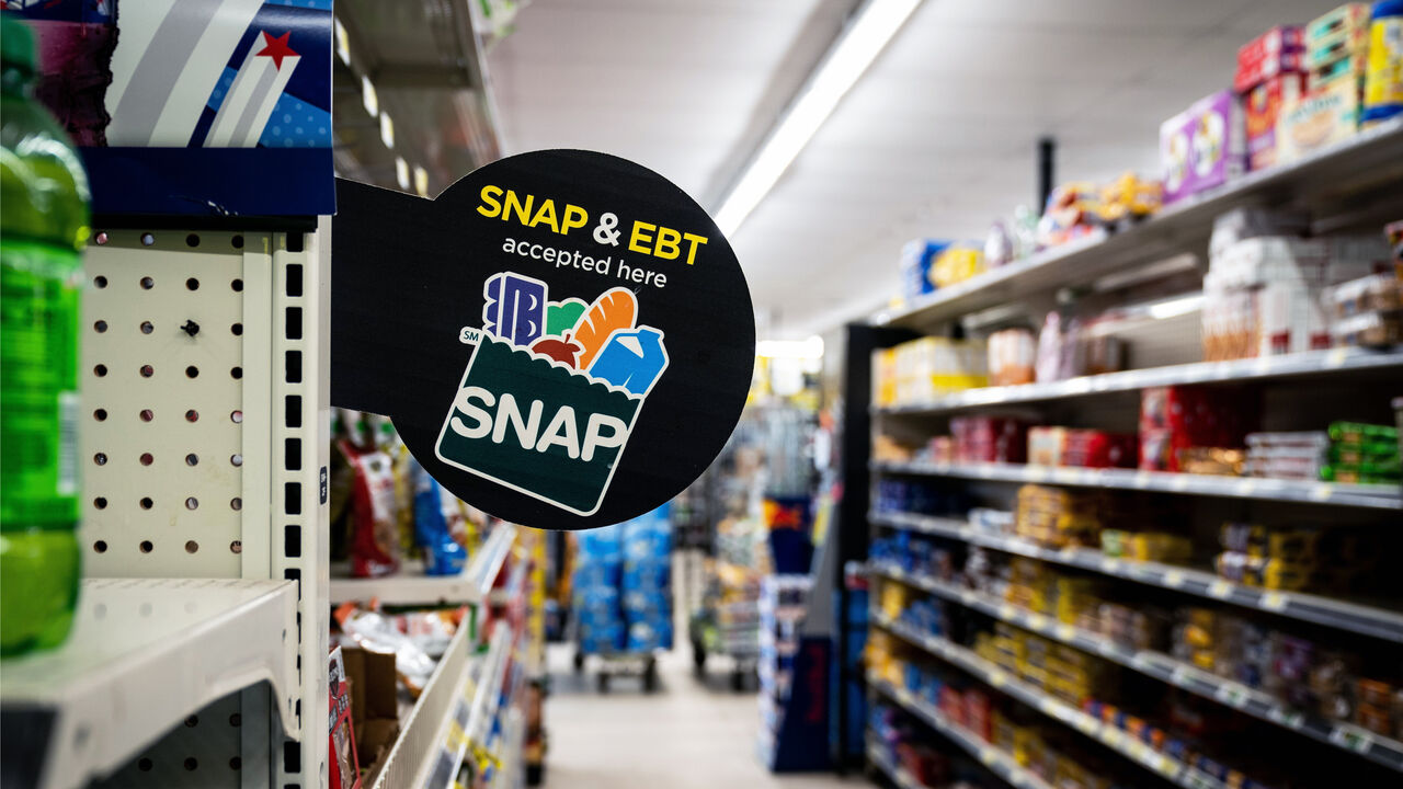 A grocery store aisle with a sign that reads “SNAP accepted here”