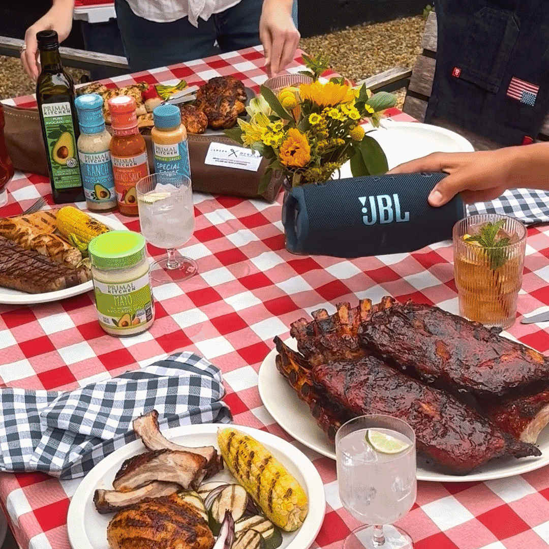 A picnic table with Primal Kitchen sauces and summer foods