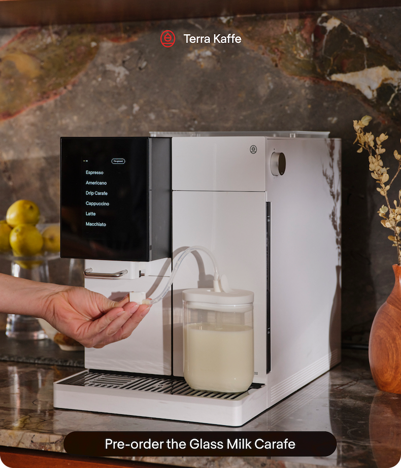 an image of a coffee machine with a glass of milk on top of it