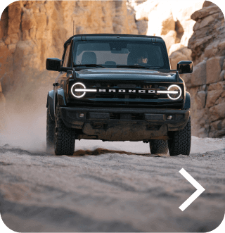 A Bronco&reg; SUV Outer Banks&reg; model being driven off‑road in a desert landscape