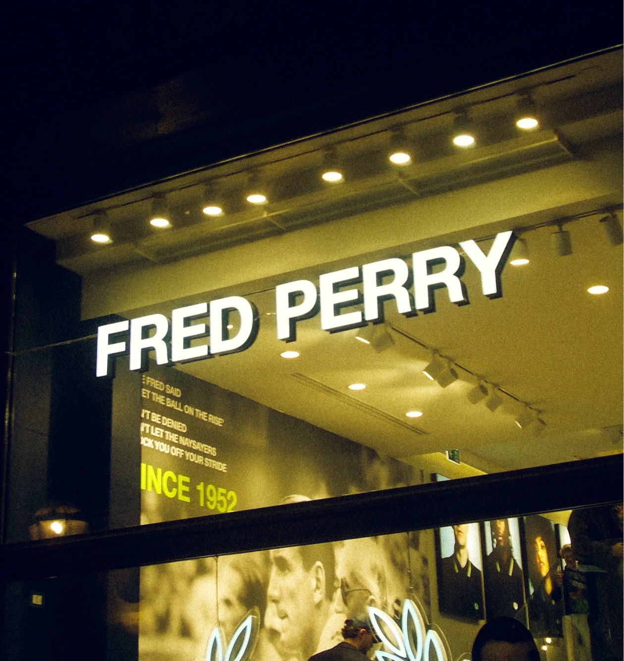 A male model wearing a solid colour long sleeved Fred Perry Shirt in Night Green