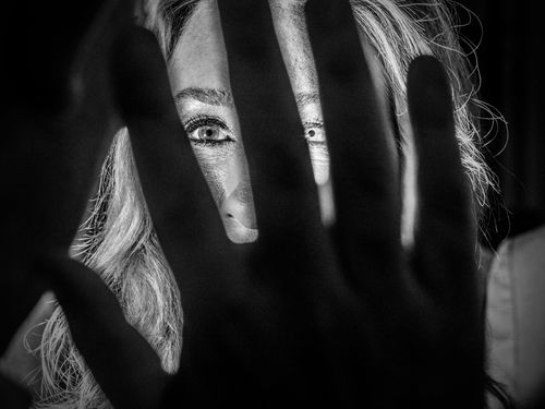 A hand in front of a woman's face