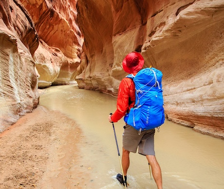 a man walking through a narrow slot in the narrows
