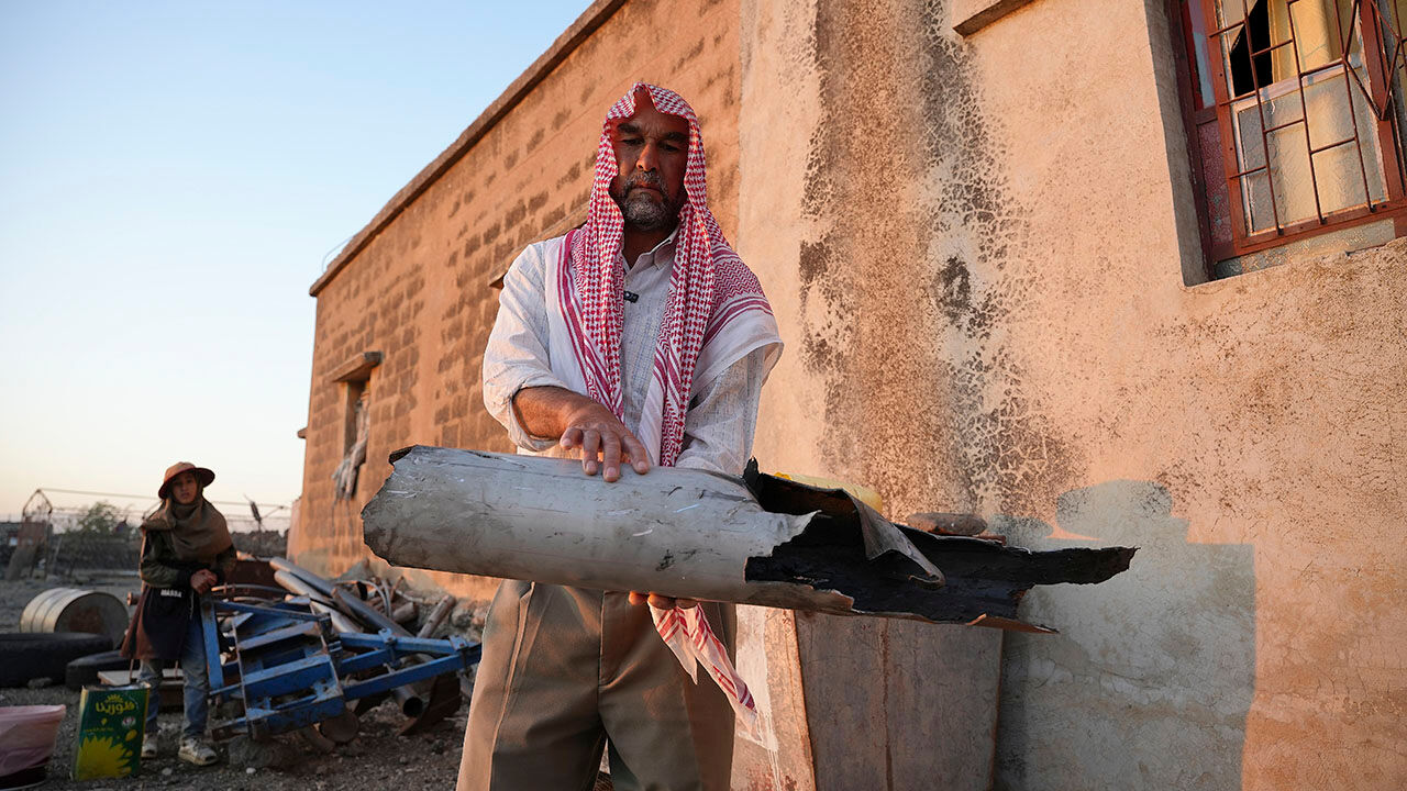 A Syrian man holds a destroyed part believed to be of Iranian drones that were shot down by Israeli air defenses, in Jbeiliah village, southern Syria,