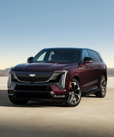 Cadillac Escalade IQ Sport parked at an angle in a desert environment with clear blue skies in the background.