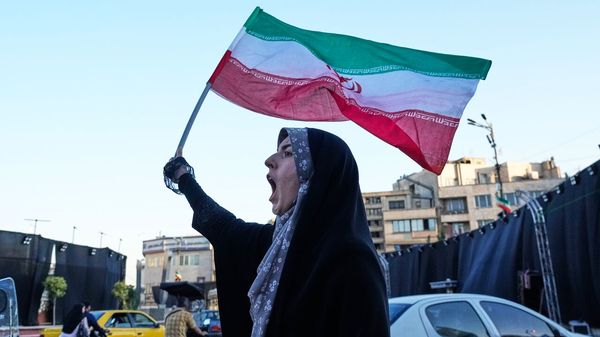 A woman waves an Iranian flags as she chants slogans against Iran and U.S. talks at the Islamic Revolution square in Tehran, Iran.