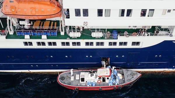 This aerial view shows health personnel assisting patients onto a boat from the cruise ship MV Hondius, while stationary off the port of Praia, the capital of Cape Verde