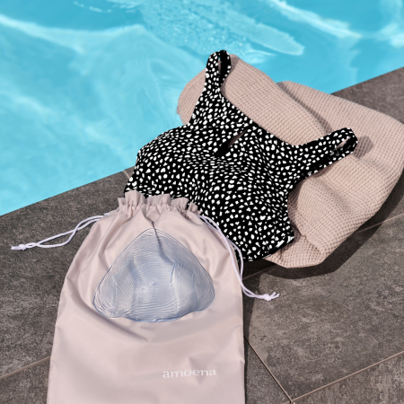 amoena swimming prostheses lie on a towel by the pool