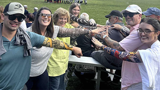 A group of people show their tattoo sleeves.