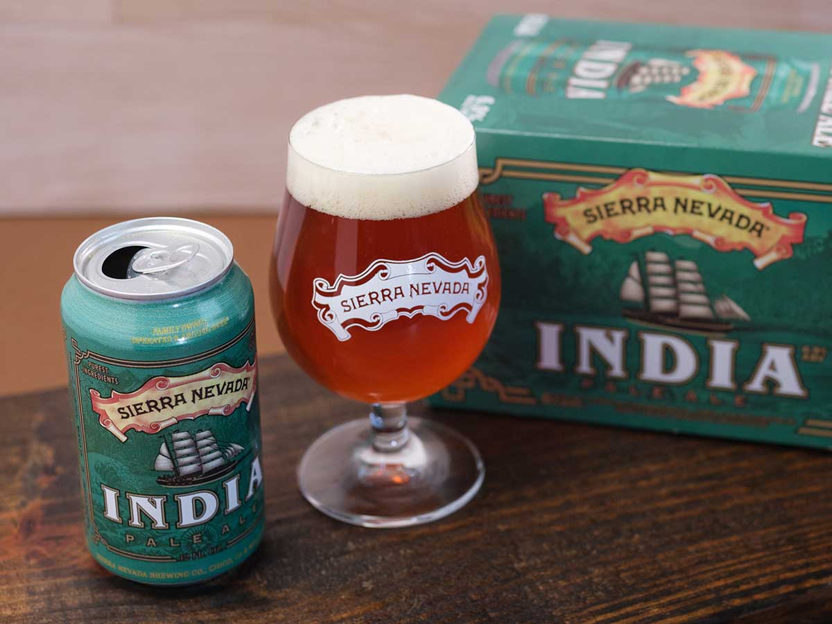 A can, full glass, and six-pack of English-style India Pale Ale
