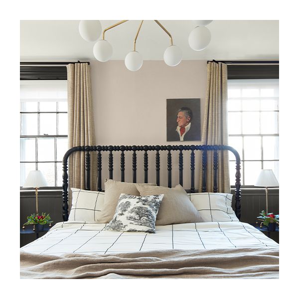 A beige and dark gray two-tone painted bedroom wall behind a black bed.