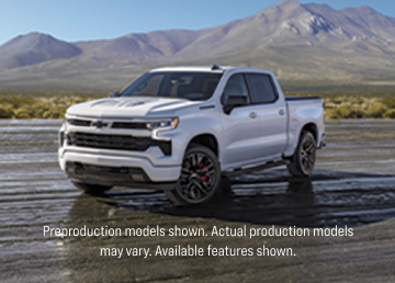 Side angled shot of the Stars and Steel Silverado parked in a dirt lot with mountains in the background.