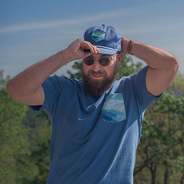 A man wearing a hat and t-shirt from the Sierra Nevada x National Park Foundation Limited-Edition Collection