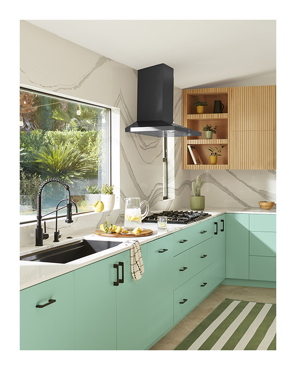A white kitchen with lower cabinets painted in light mint green.
