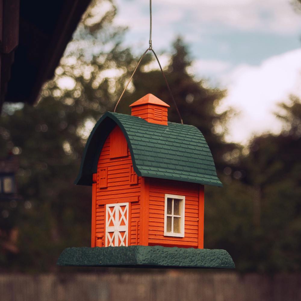 A bird feeder shaped like a red barn. 