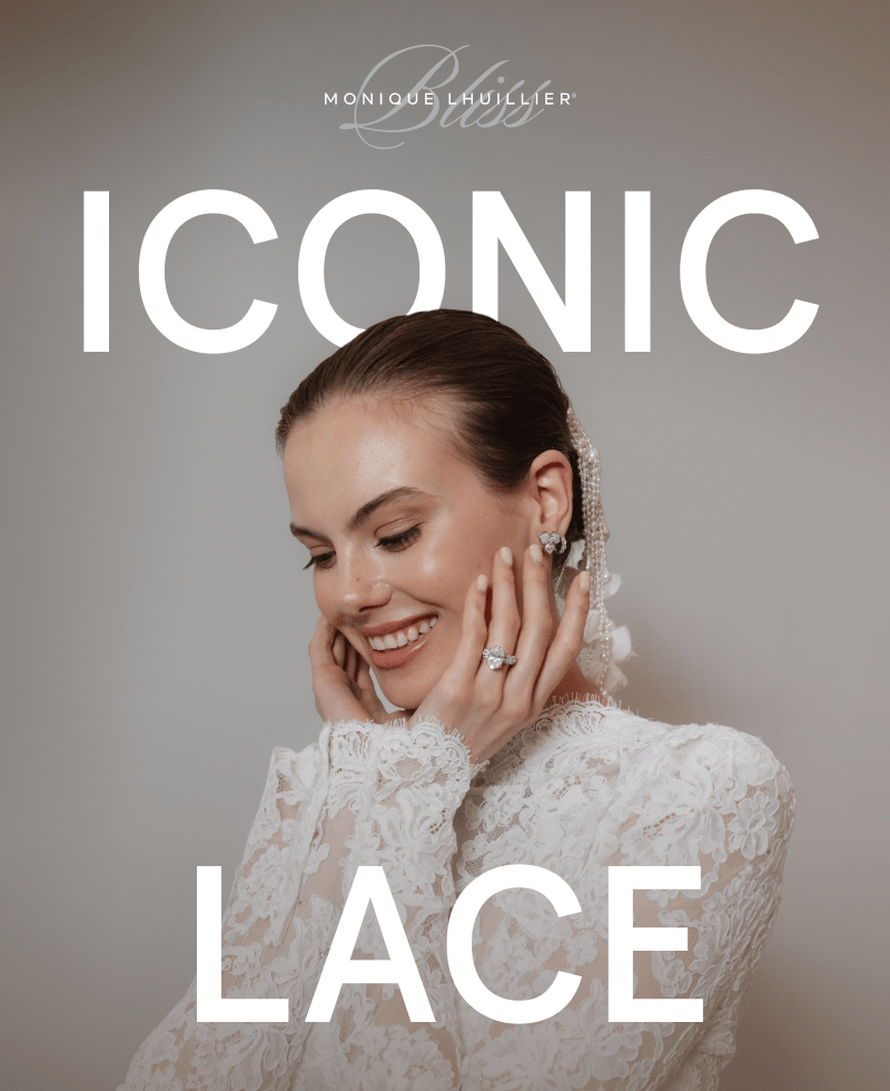 A model wearing diamond earrings and a ring in a white lace wedding dress.