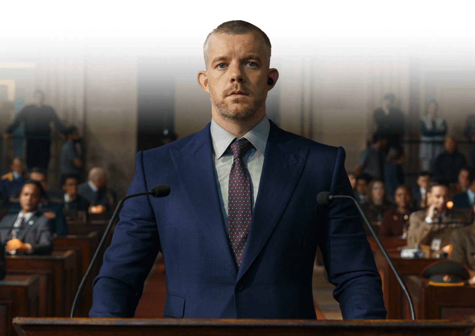 Barclay Pierre-Dupont, played by Russell Tovey, stands at a court podium in a suit.