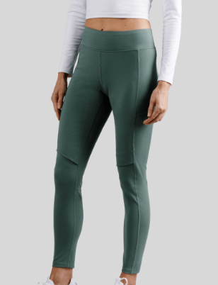 a woman wearing a white crop top and green leggings