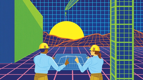 two construction workers with UMD hard hats look at blueprint