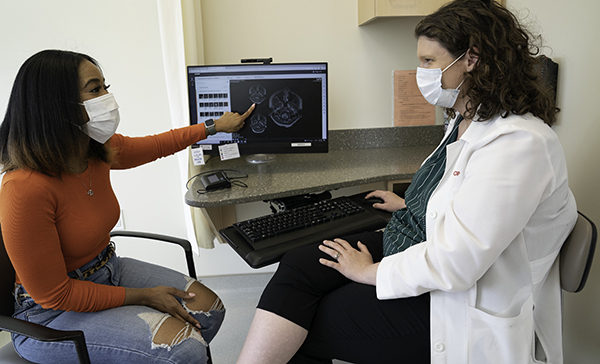 A female patient sits with a female doctor.
