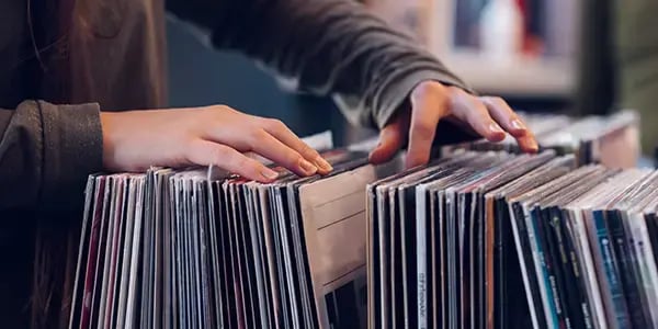 Hands flipping through record albums in a shop