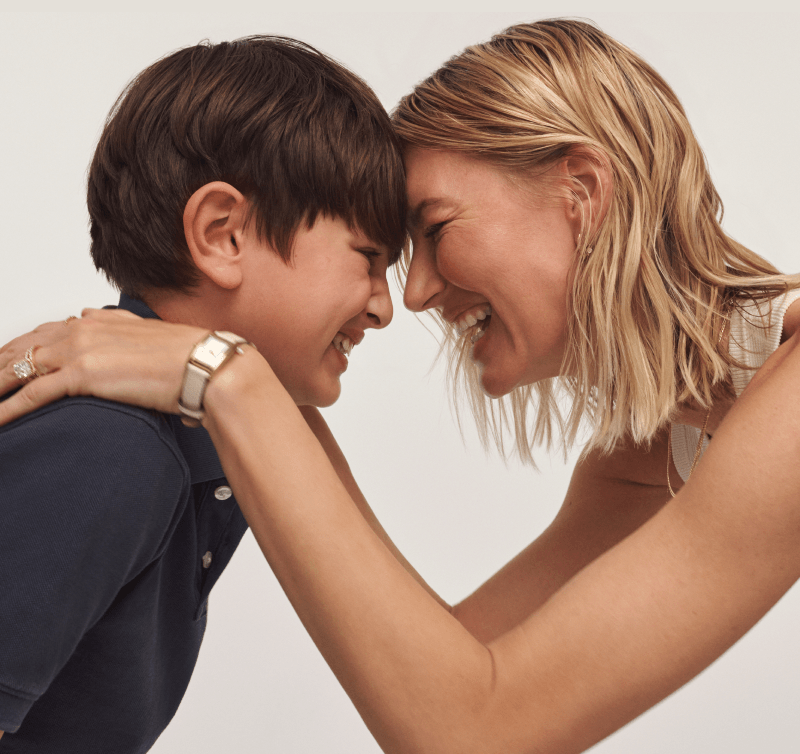 Mom and son embracing. Mom wearing a watch and diamond ring. 