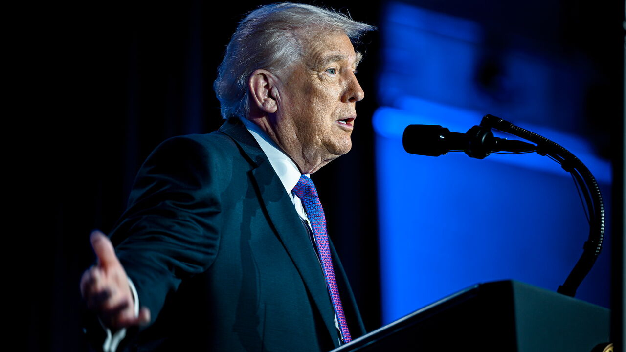 President Donald Trump gestures with his hands as he speaks at an event.