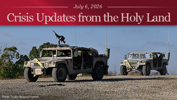 Israeli soldiers driving two military vehicles along the Israeli border with the Gaza Strip.