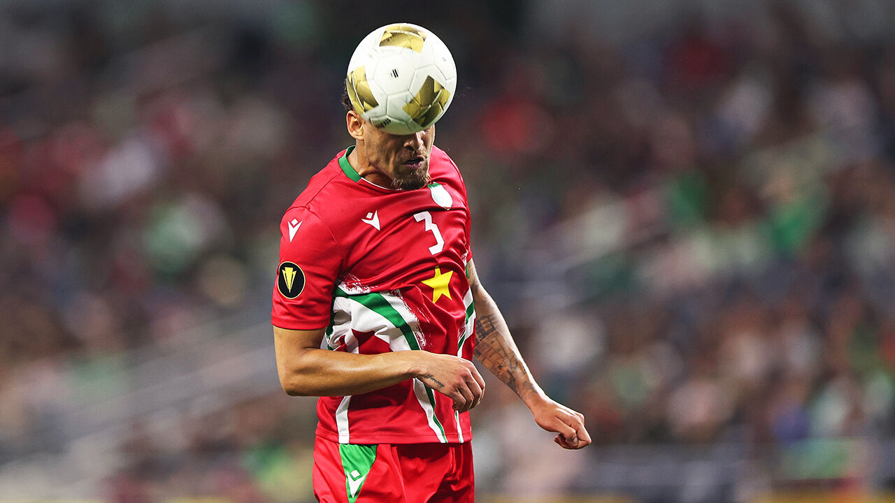 Suriname player heads the ball during a game with Mexico  