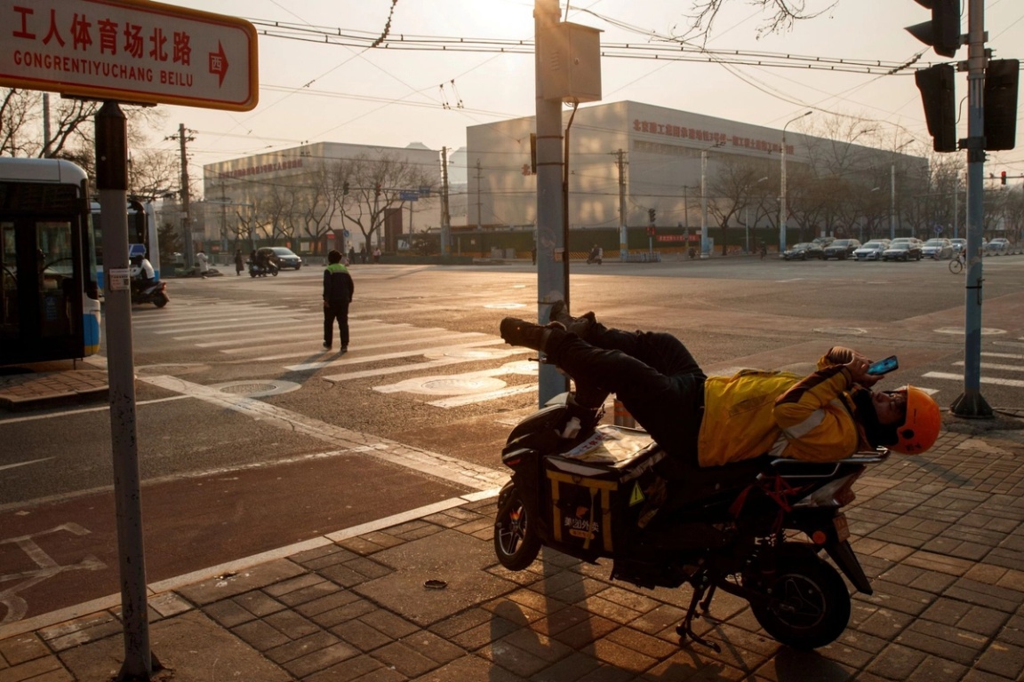 A delivery driver reclines on his bike in Beijing