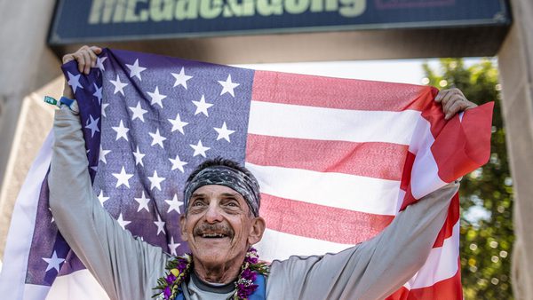 Bob Becker holds up American flag at finish line of Mt. Gaoliging Ultra