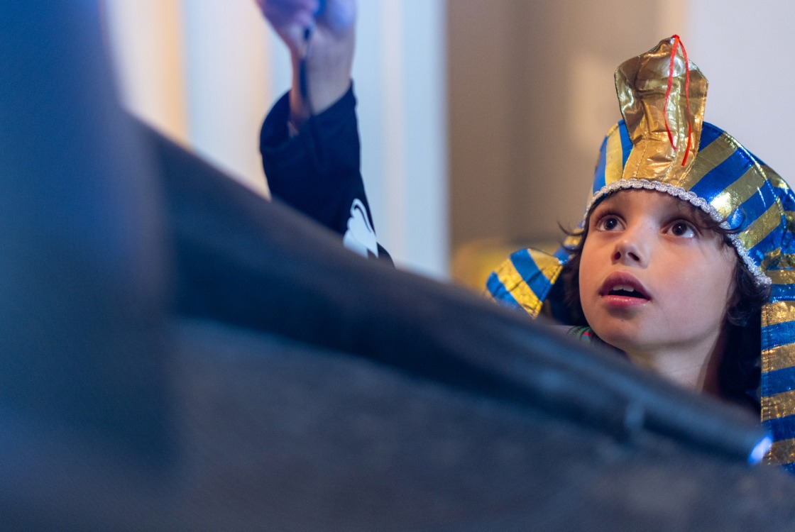 A child at a sleepover at the British Museum wearing a pharaoh headdress. 
